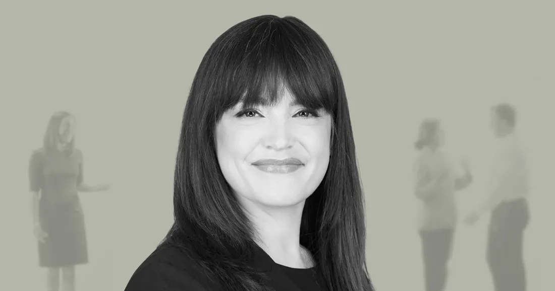 Black and white team headshot over a faded office